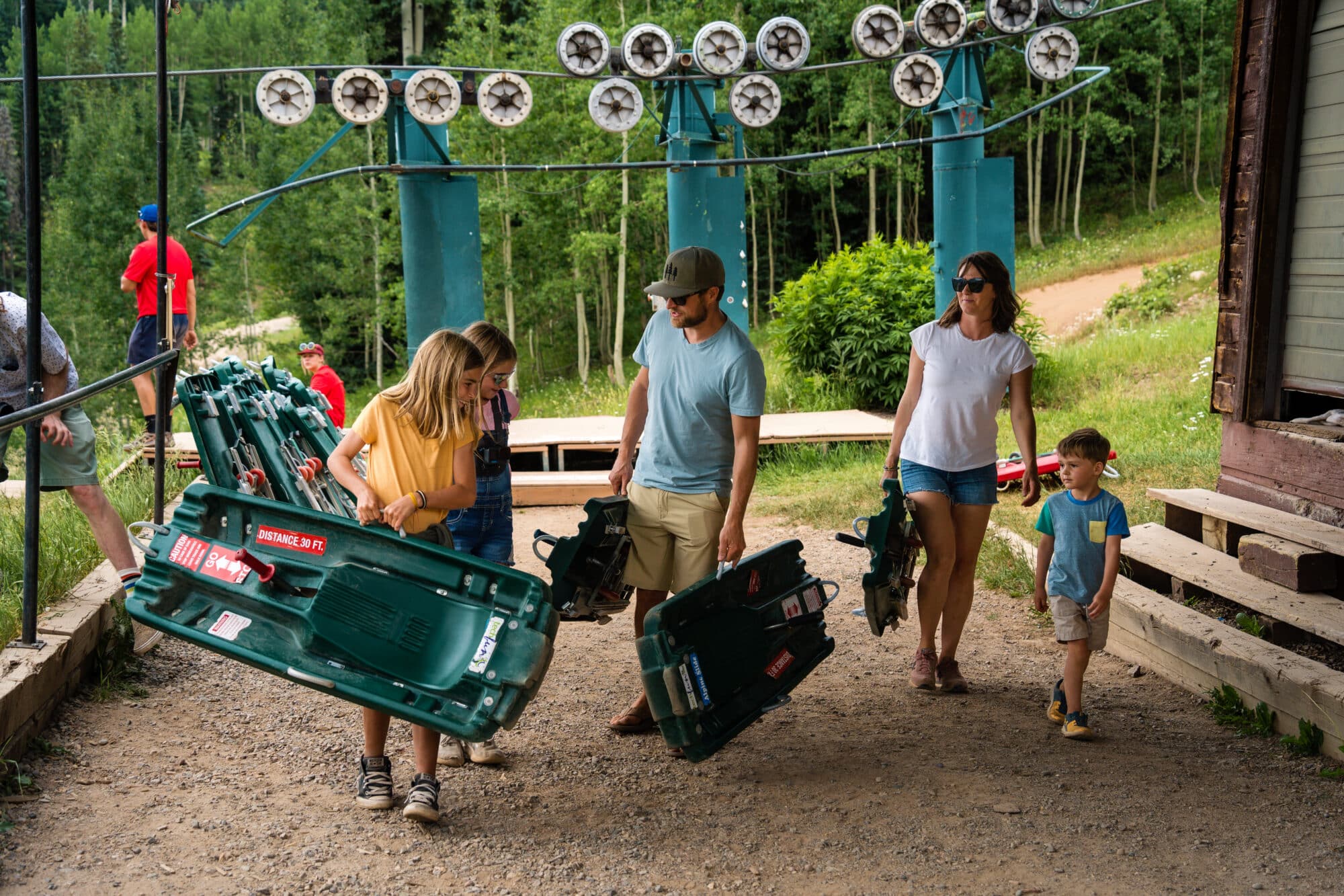 Family unloads chairlift and picks up their sled for the Alpine Slide