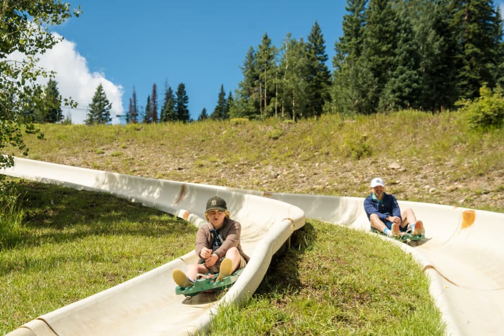 Father and son race around the first turn on the alpine slide at Purgatory Resort