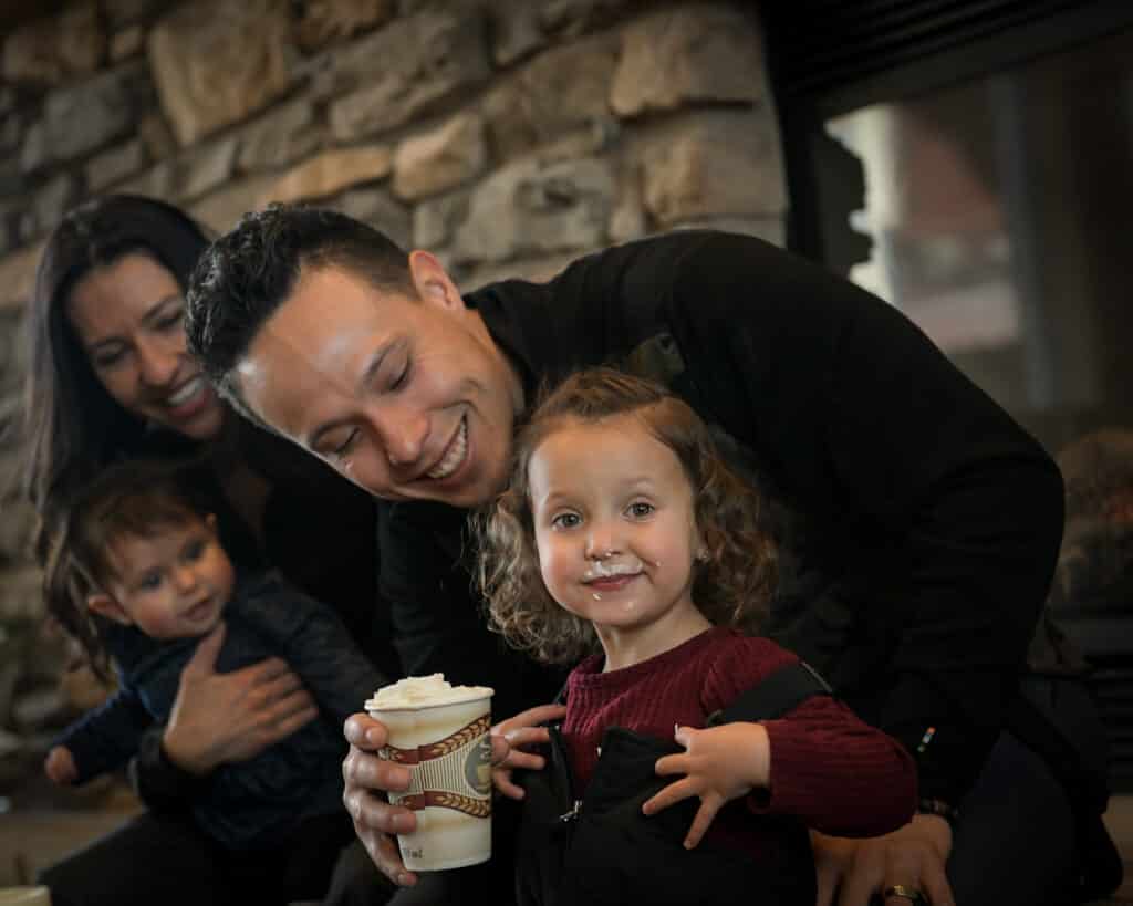 A father and daughter hold a hot chocolate