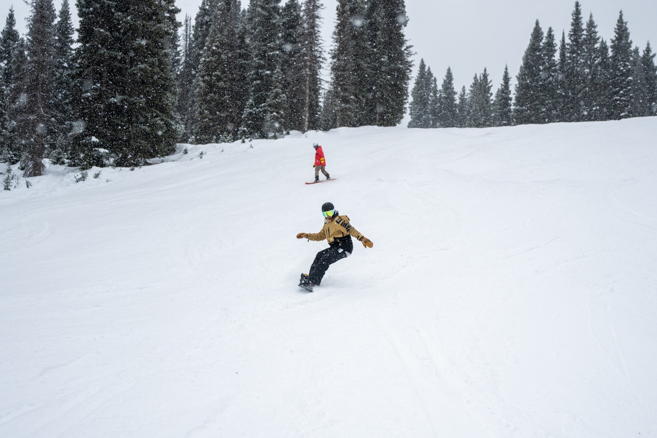 first tracks, snowboarders riding downhill