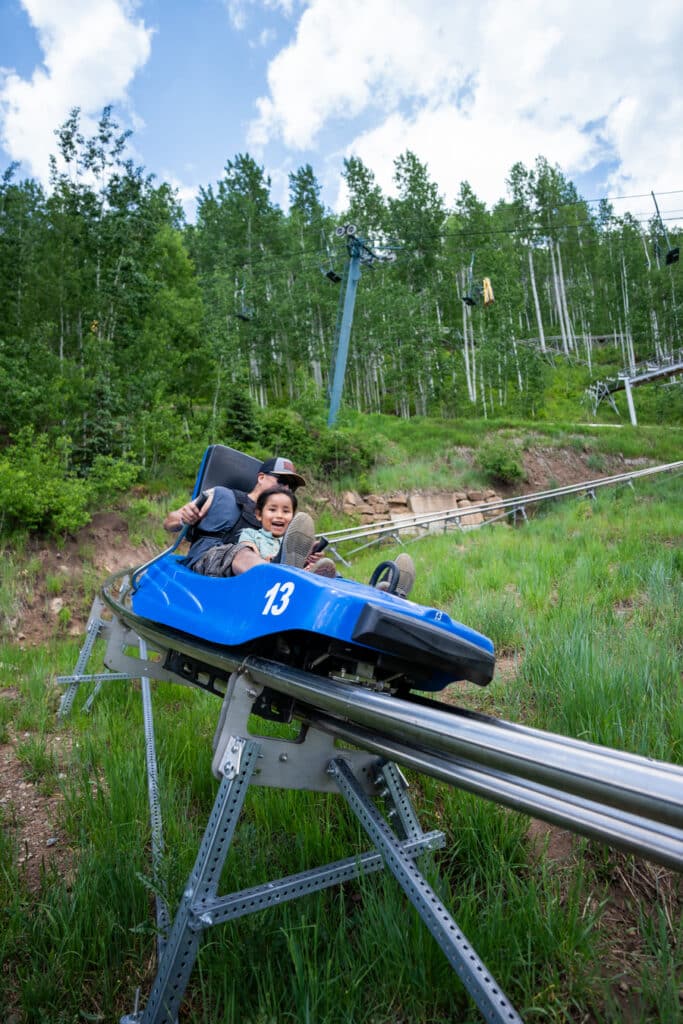 A father and child taking a turn on the mountain coaster