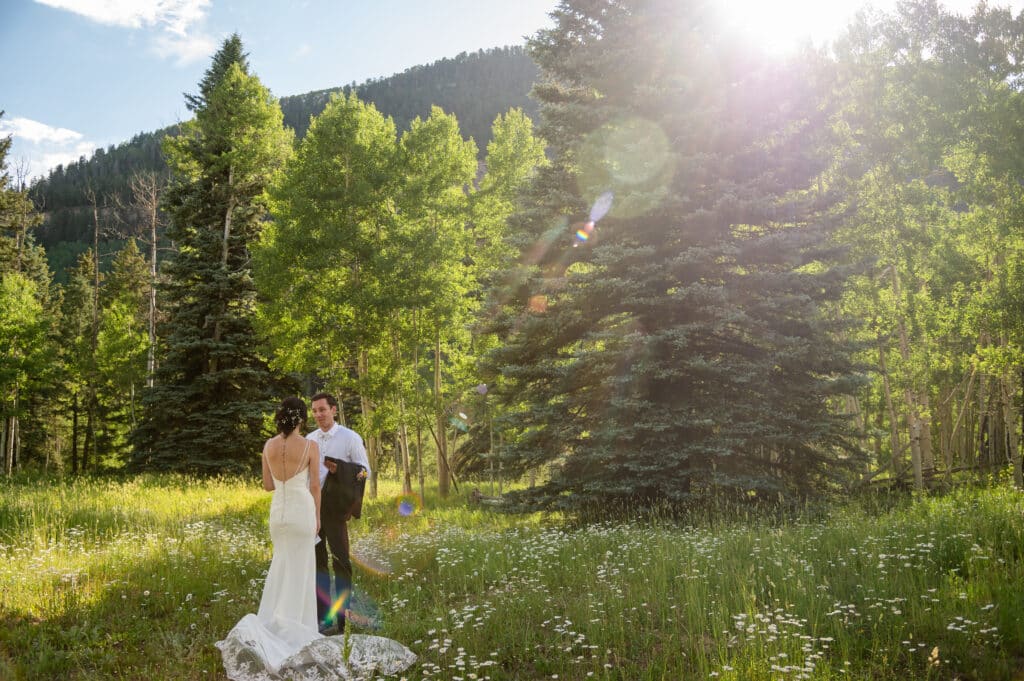 Bride and groom first look in field of daisies