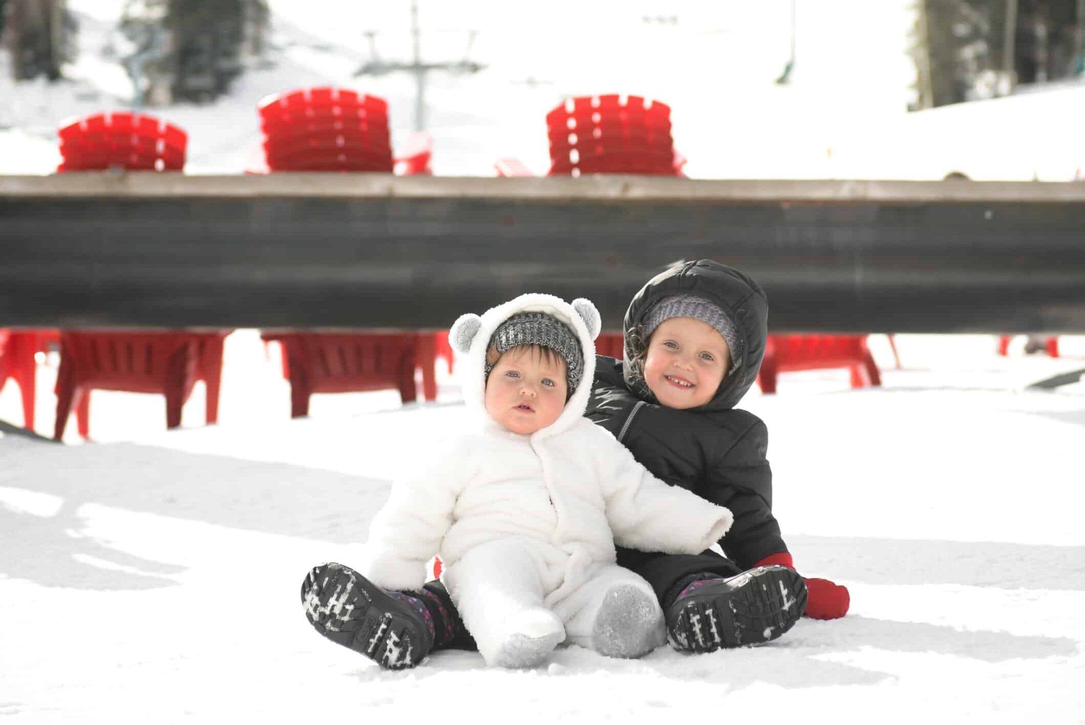 Brother and sister sitting on the beach at Purgatory Resort