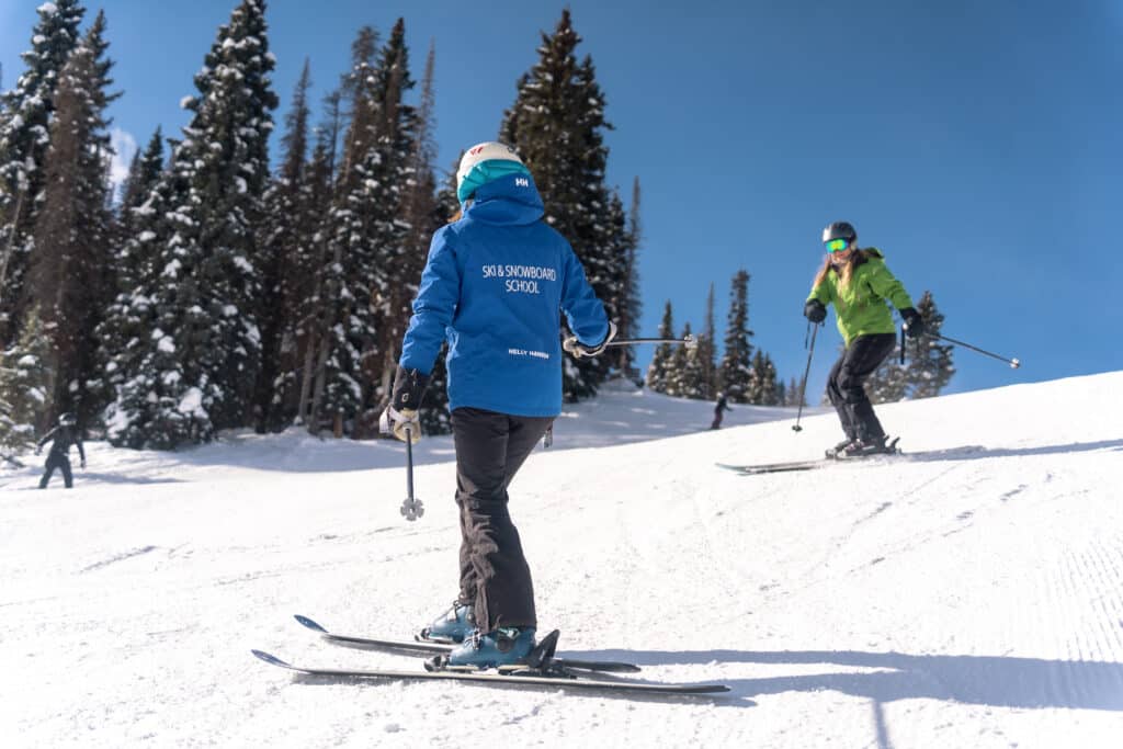 Ski School instructor points to the line she wants her student ot make