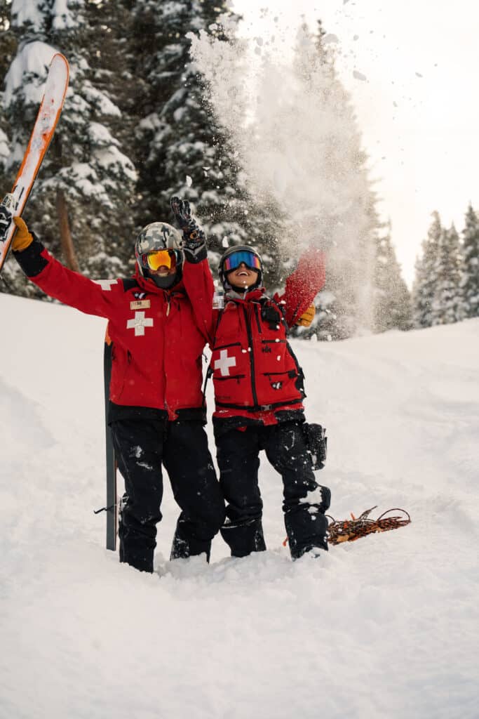 Ski patrol celebrates some overnight snow by throwing it in the air