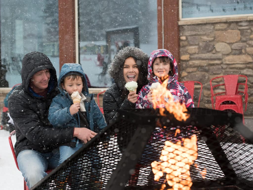 family smiling around fire